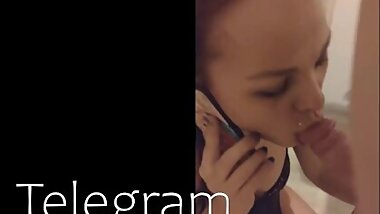 Sucks on a friend and talks to her husband on the phone